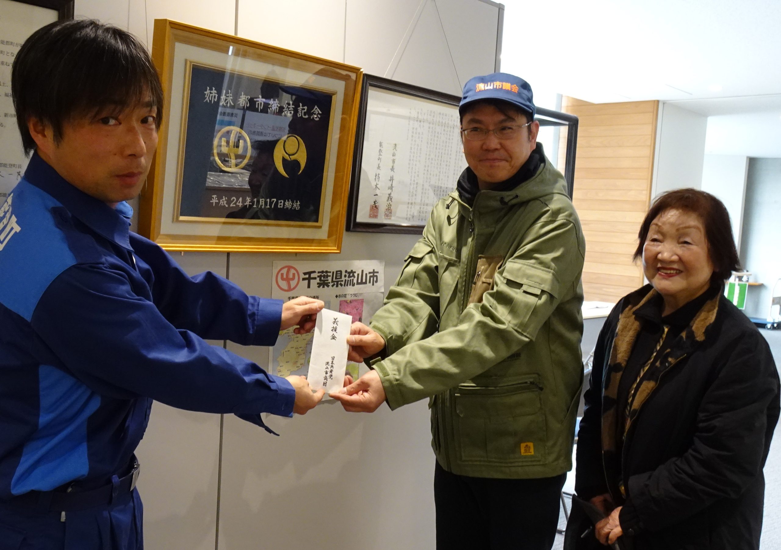 能登町と流山市の姉妹都市をバックに、秘書課の方がご協力、頂きました。